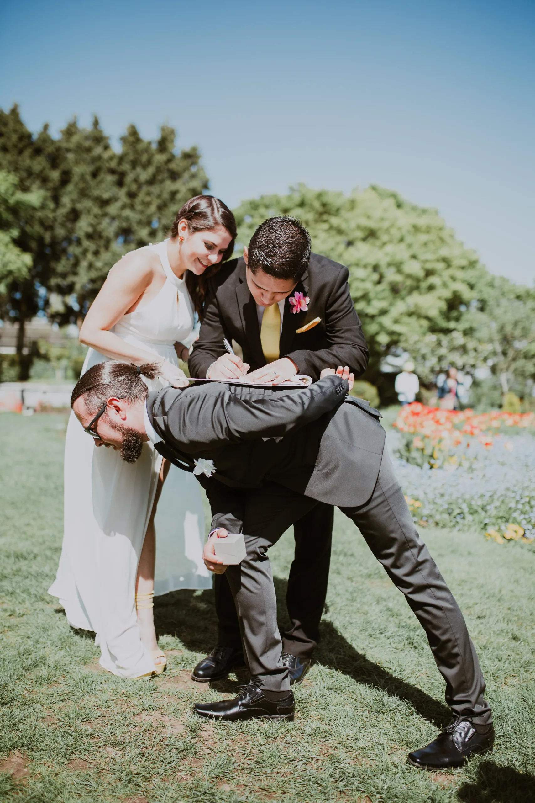 Newlywed couple signing their marriage licence on their friend's back, Erica Miller Photography