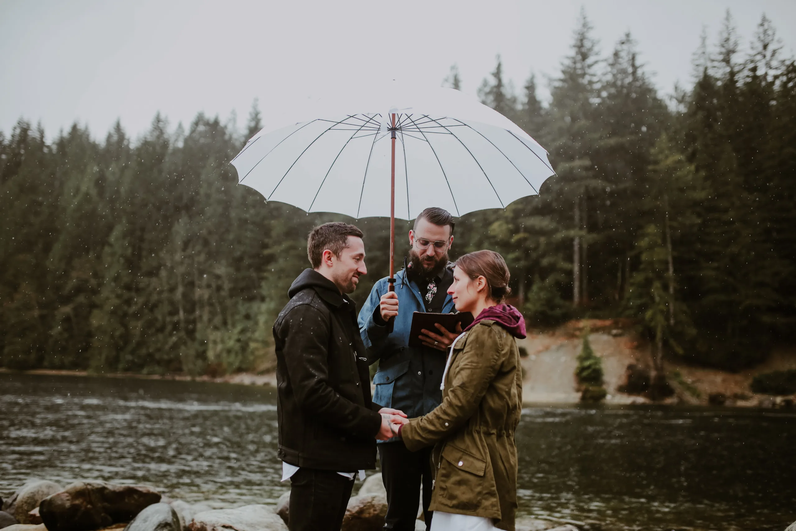 Young Hip and Married elopement ceremony with umbrellas on a rainy wedding day
