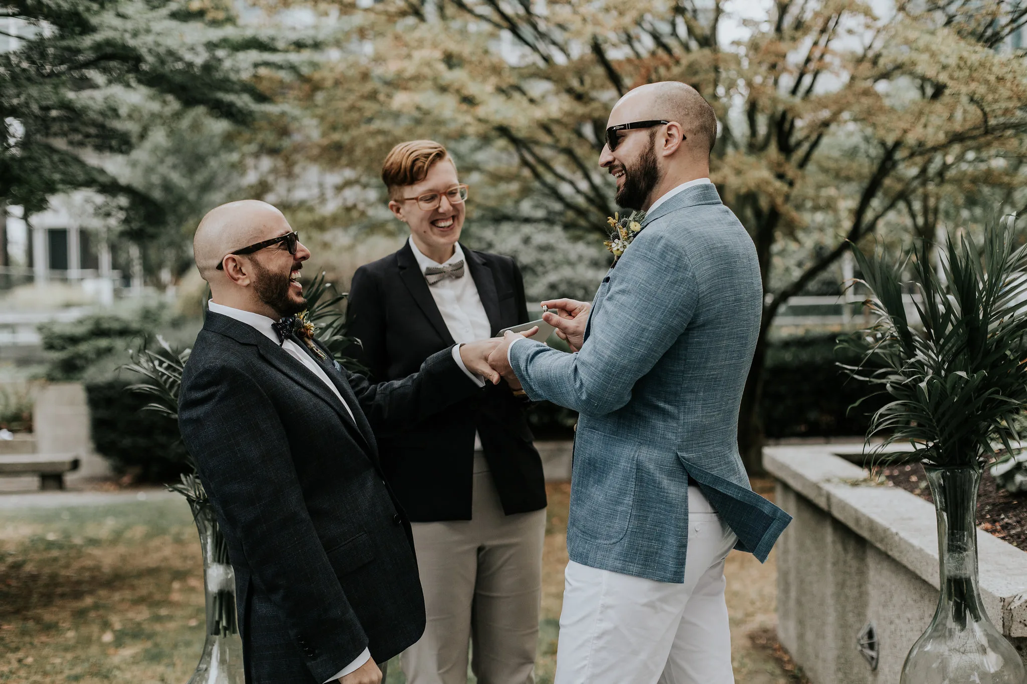 Two grooms smiling and laughing during their wedding ceremony with Young Hip & Married Officiant Beth
