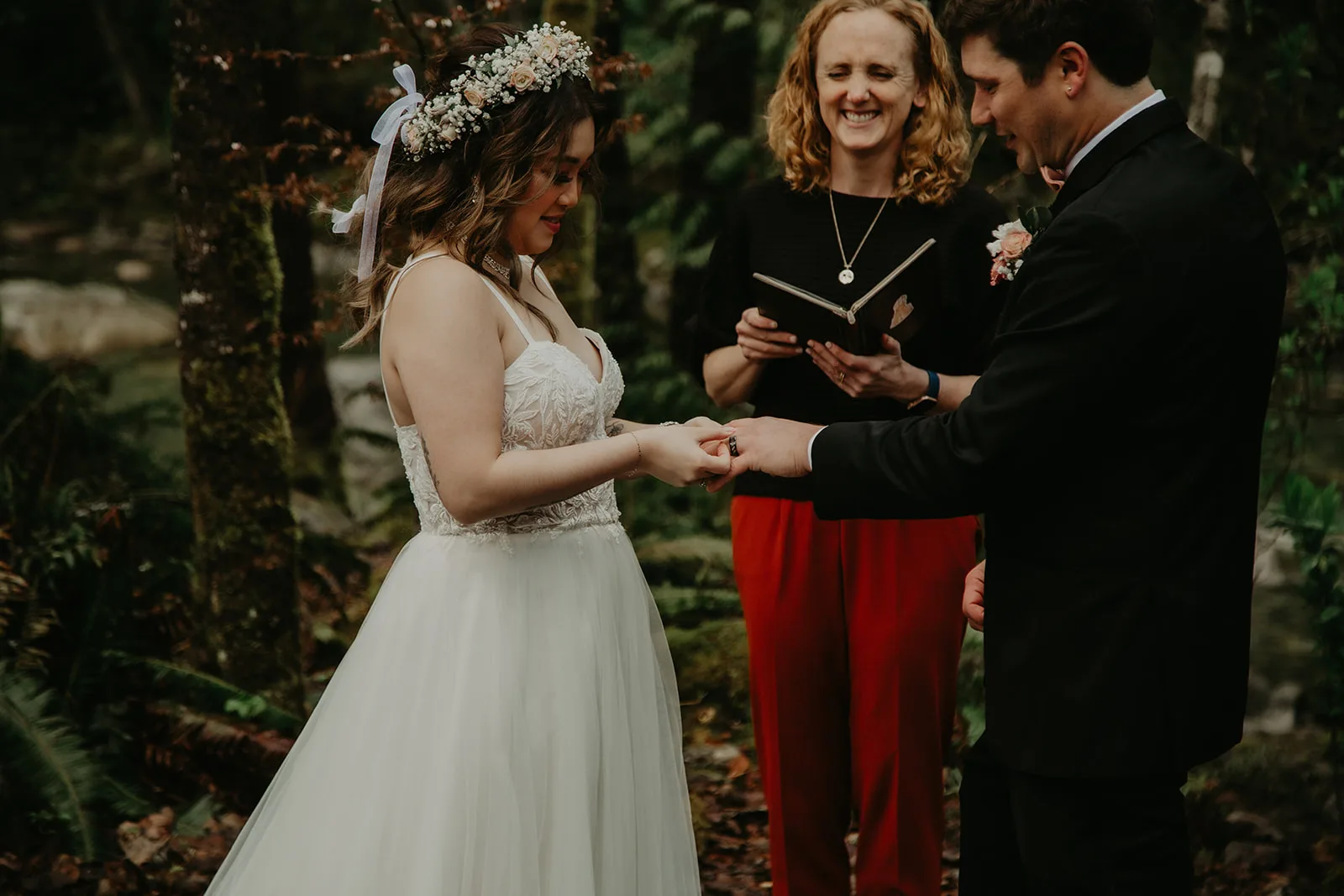 couple exchanging rings during their young hip and married stanley park elopements in vancouver