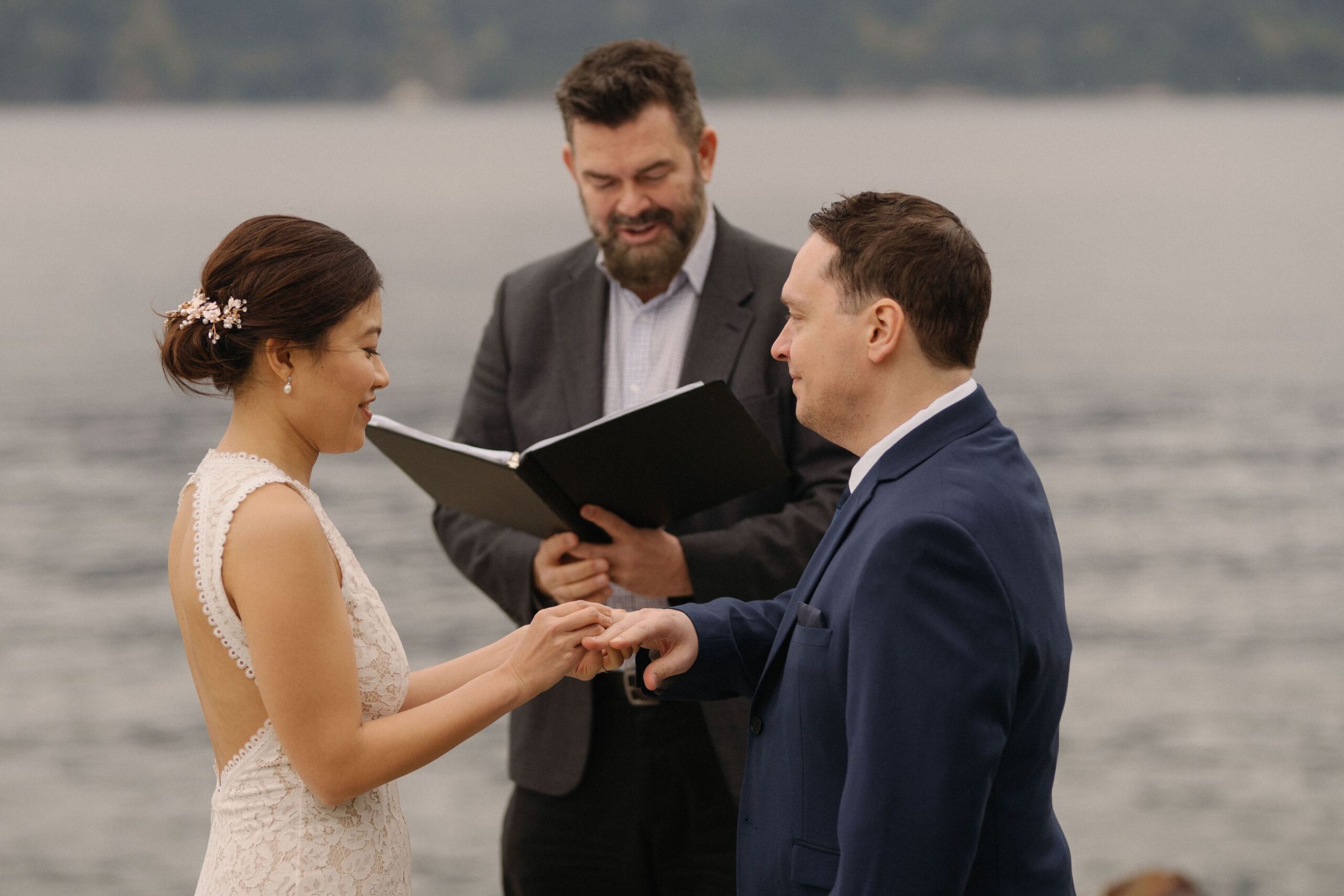 porteau cove wedding with young hip & married, officiant sharing love story as couple exchanges rings