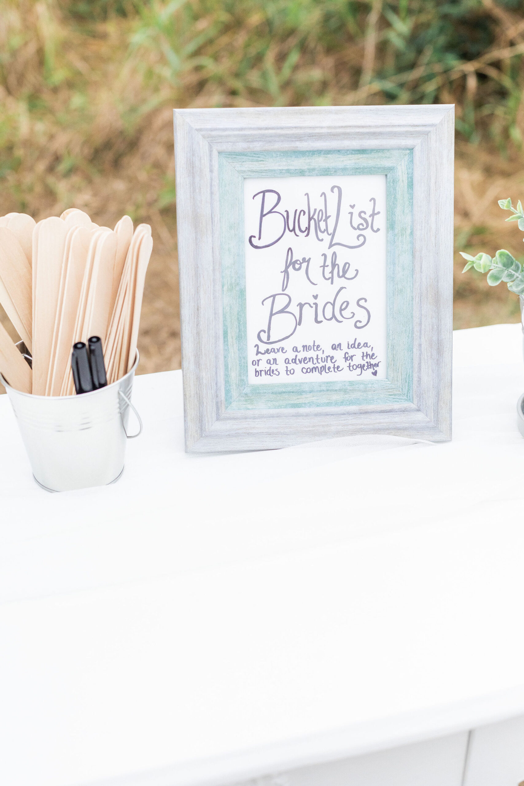 creative wedding guest book where guests are asked to write a bucket list idea on a popsicle stick