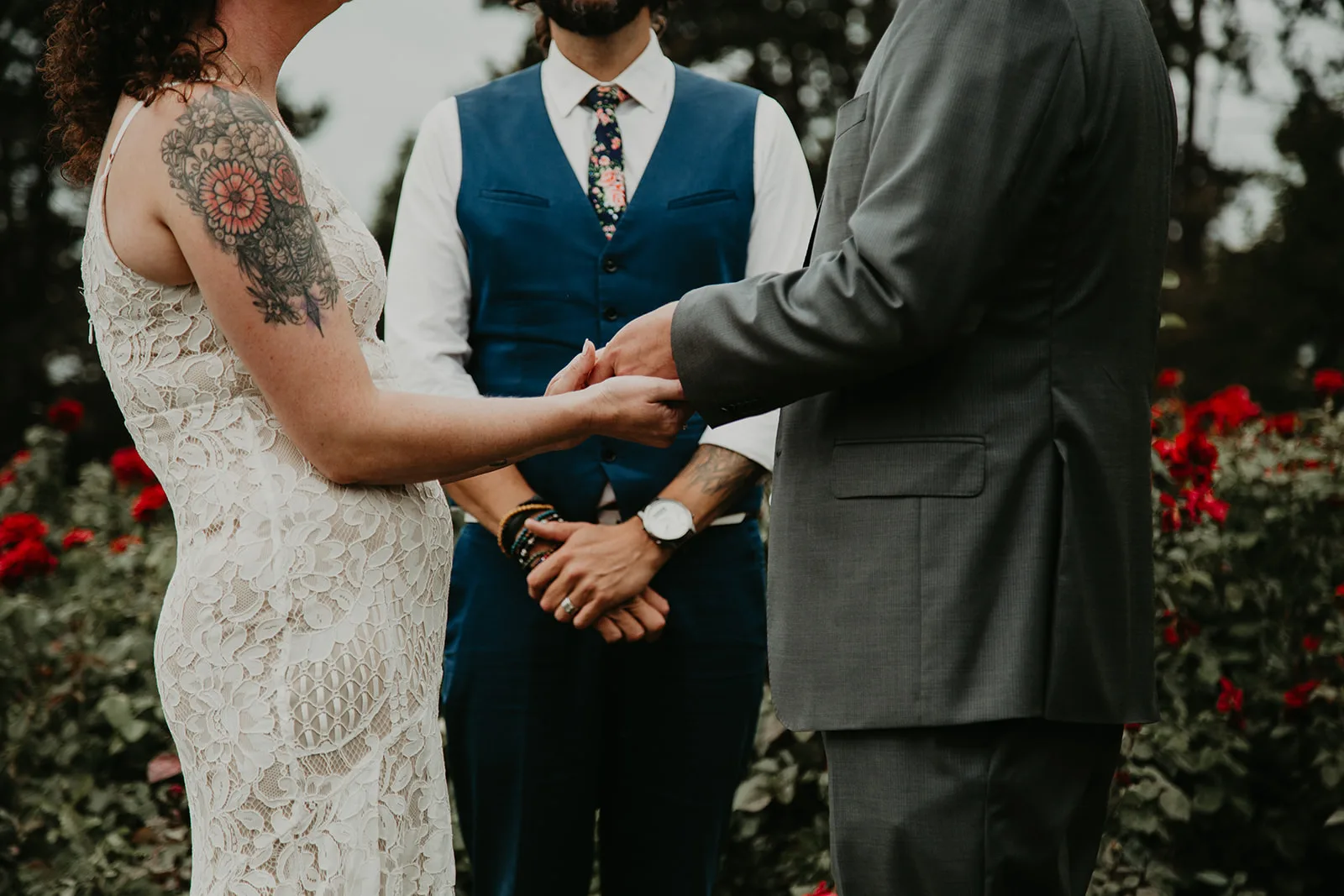 modern and cool wedding officiant outfits, blue tie and floral vest, jewelry and tattoos showing, young hip and married officiant