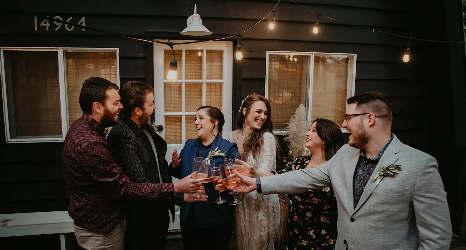 couple and their wedding party toasting glasses