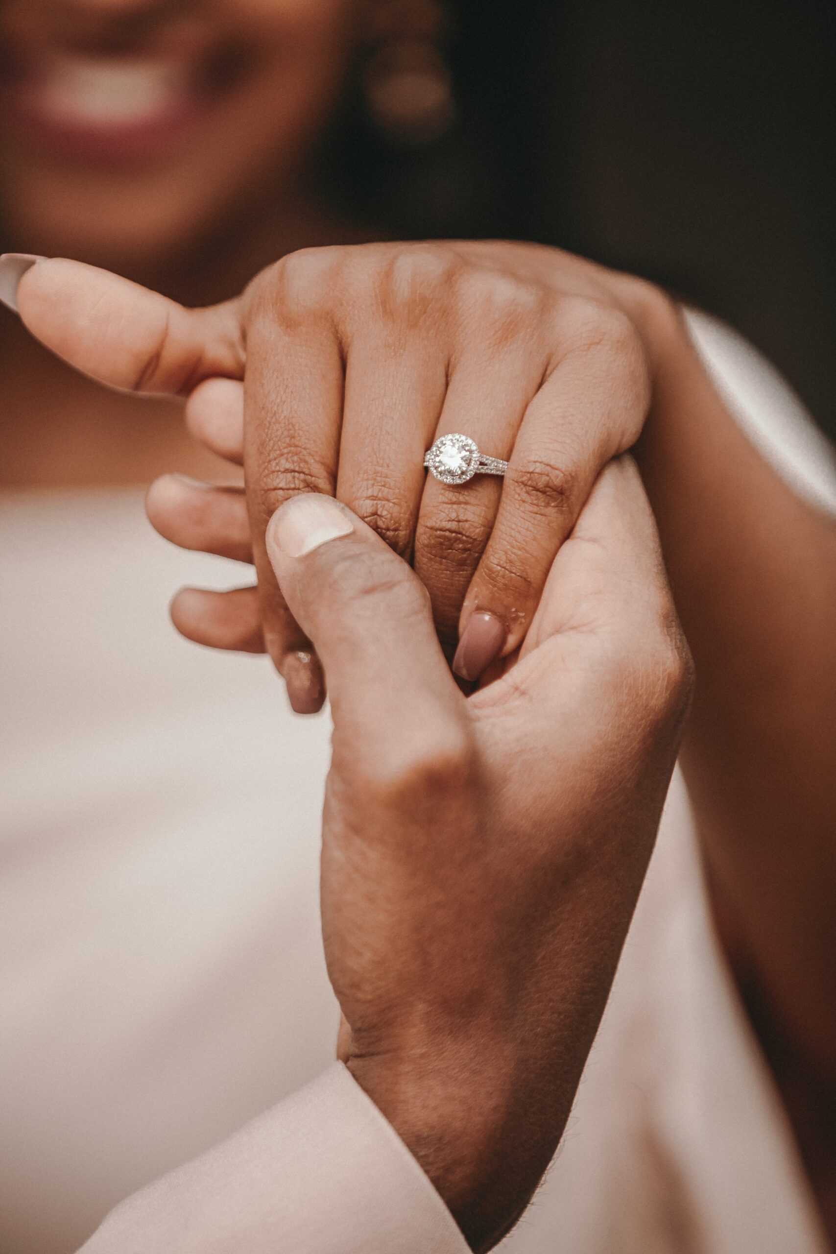 Couple's hands showing off engagement ring