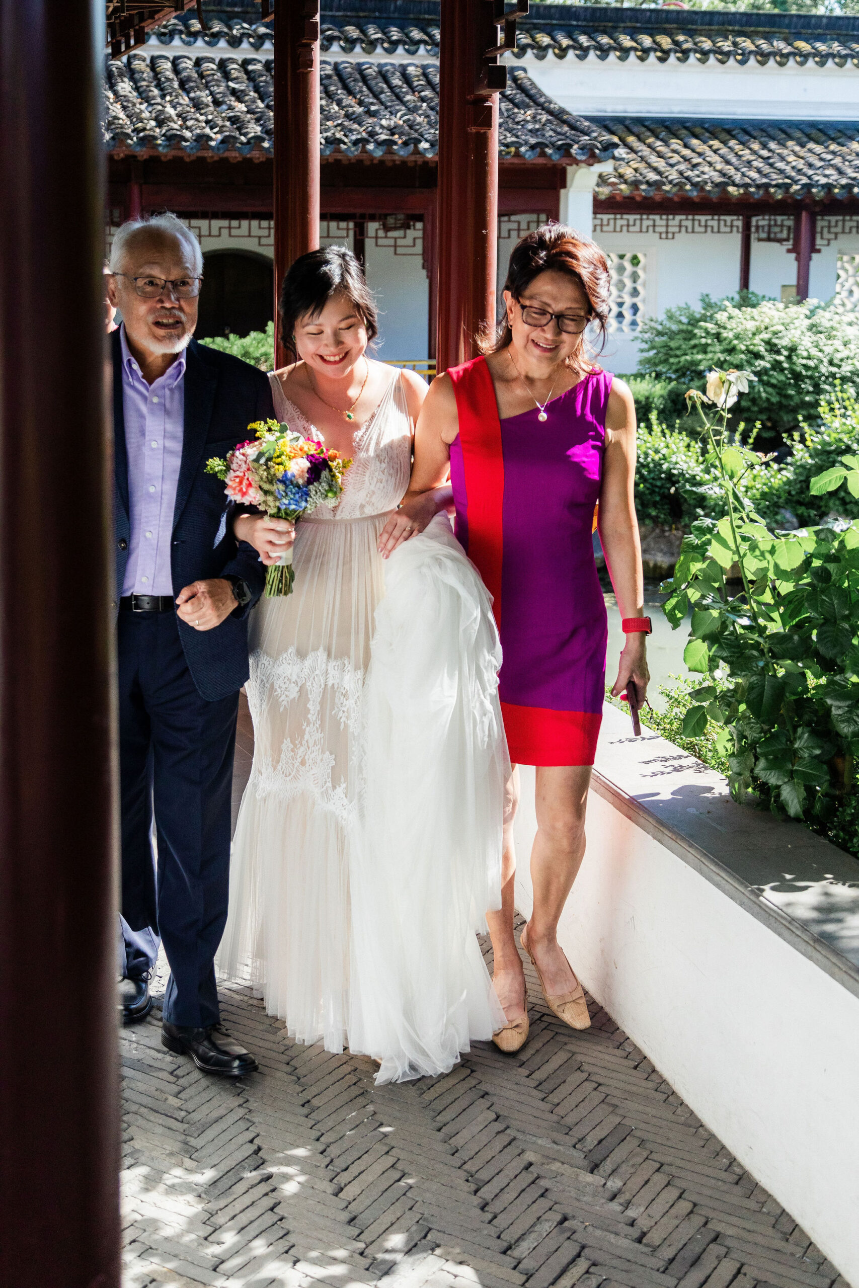 bride walking down the aisle with both her parents