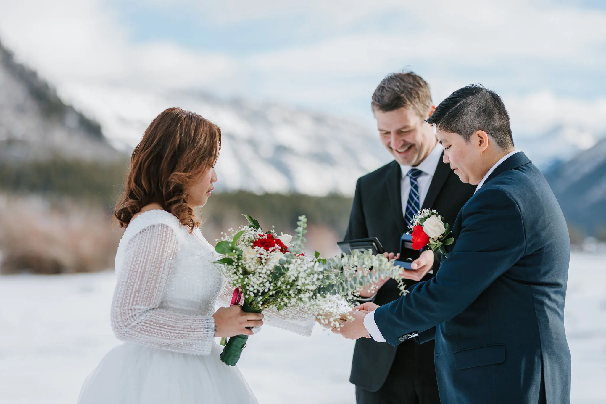 Kathlane and Michelle exchanging rings at their elopement in Banff with Officiant Rich from Young Hip & Married