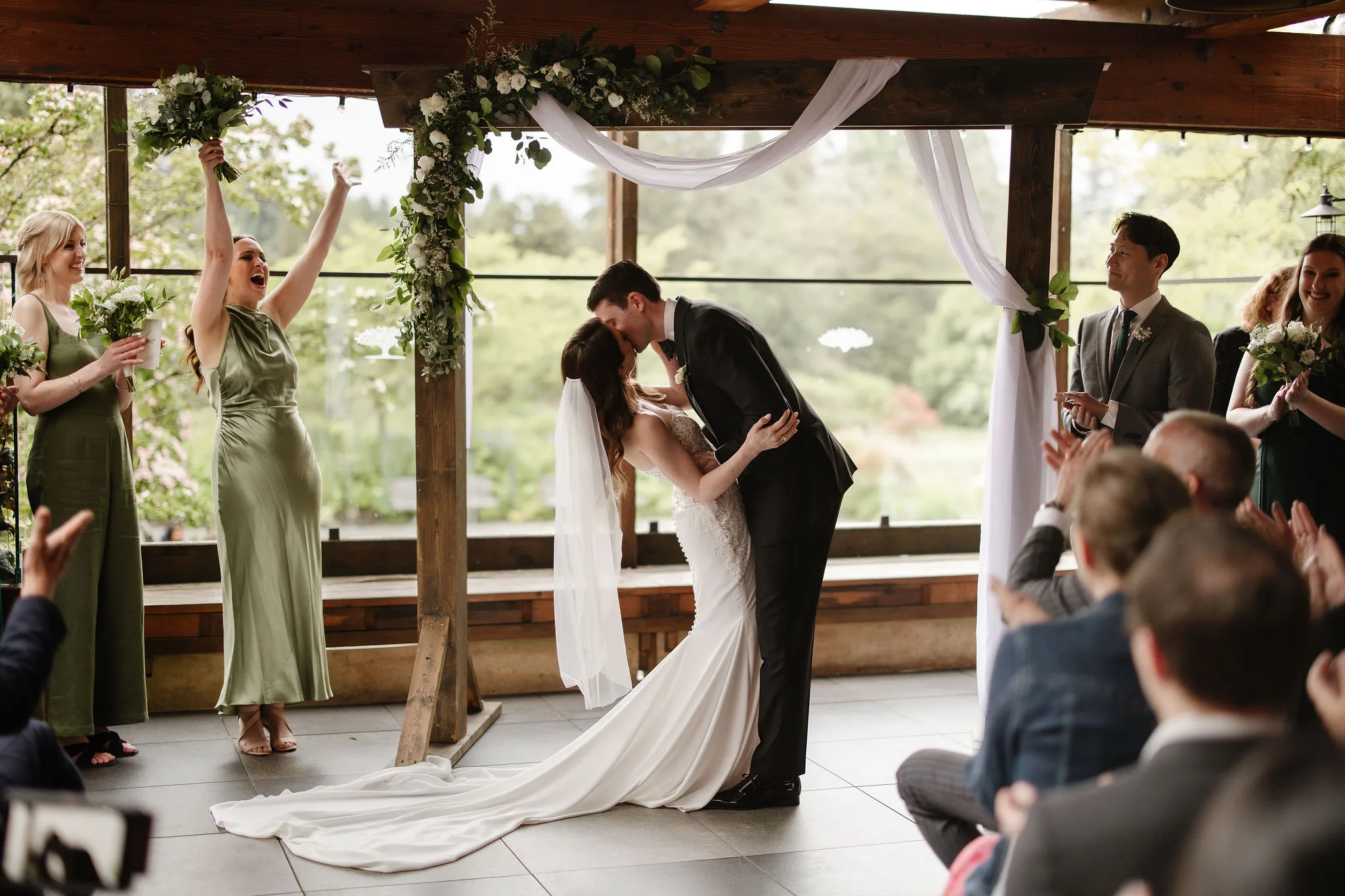 Newlyweds sharing their first kiss after their Young Hip & Married ceremony while guests cheer