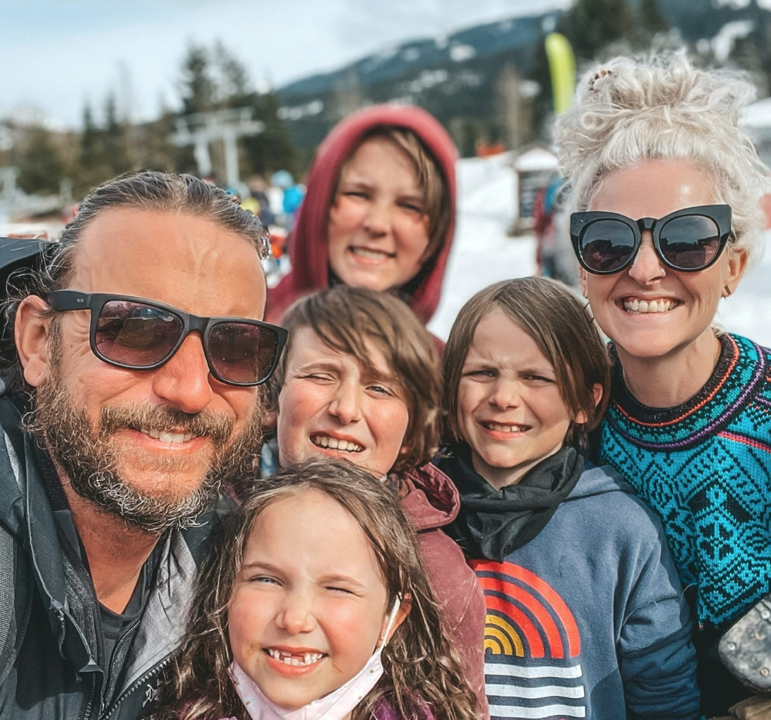 Miller family smiling for a selfie on the ski slopes
