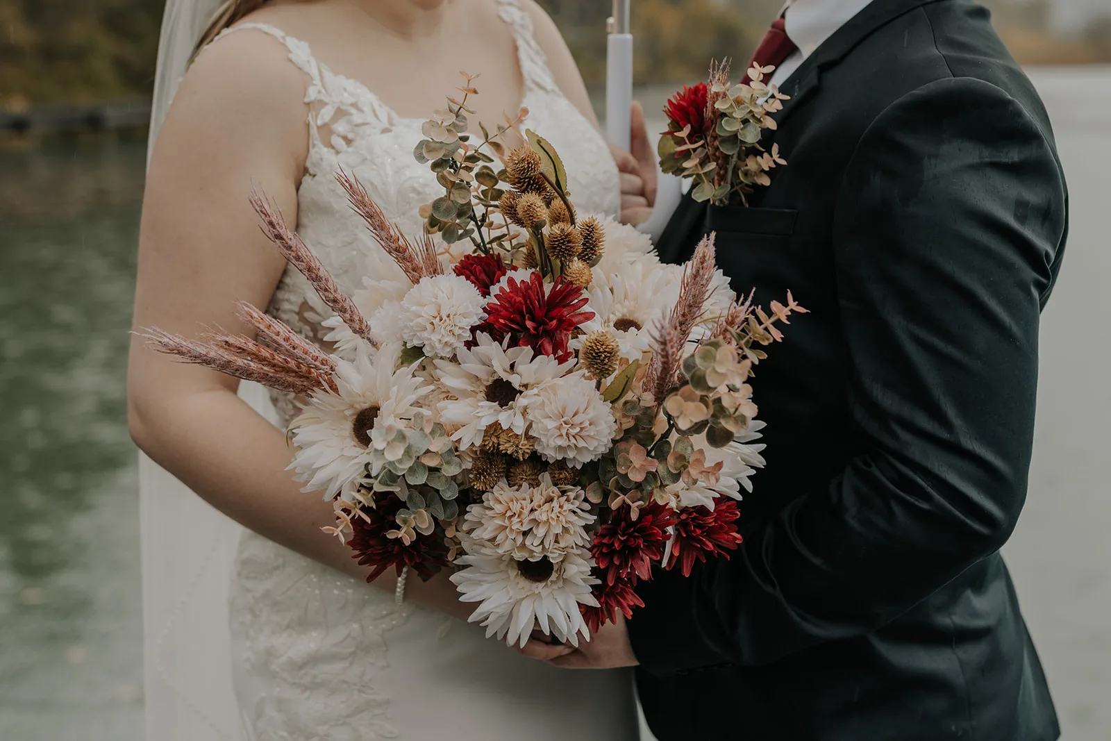 Bride and groom embracing and holding a bouquet of flowers