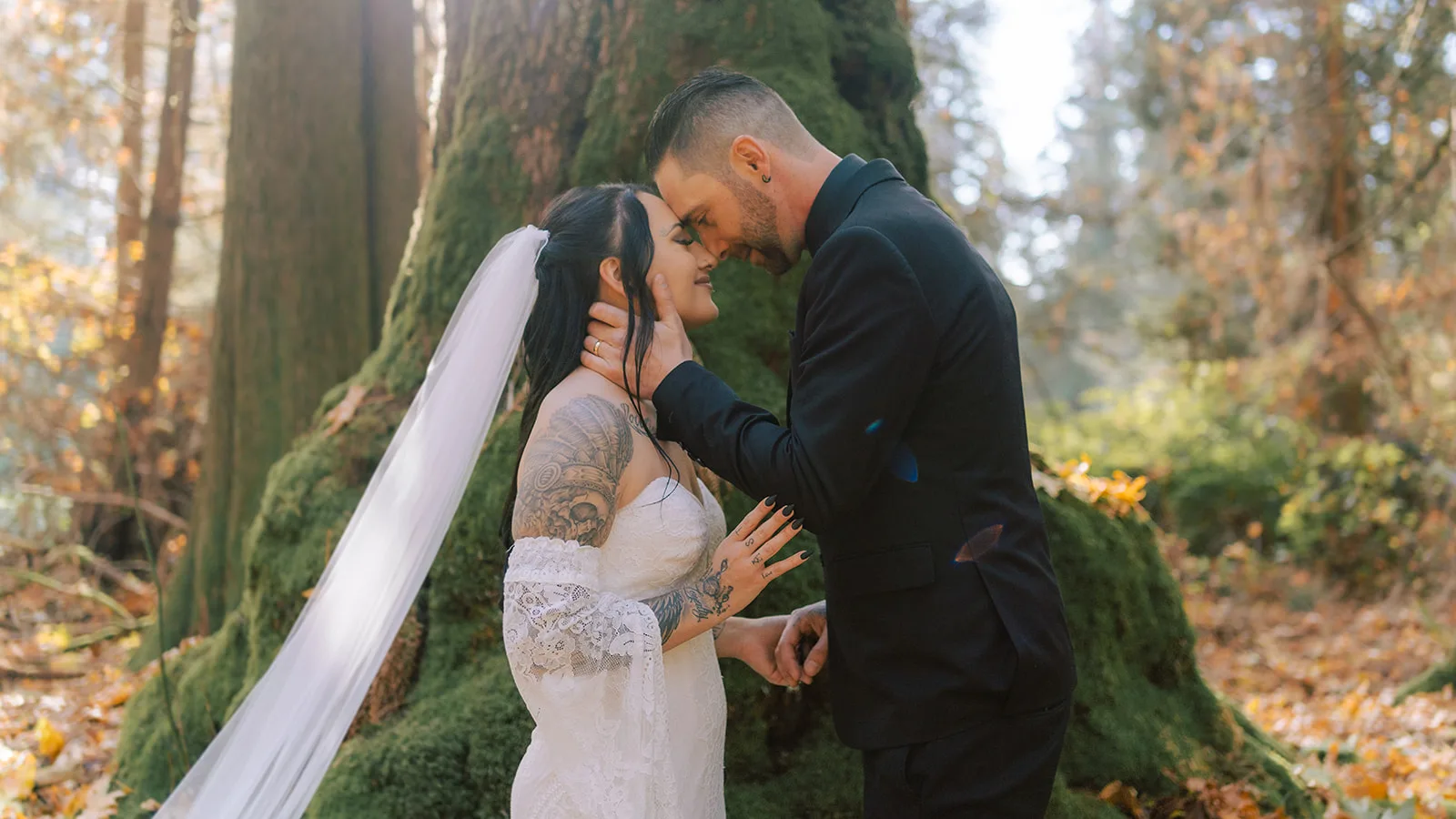 Newlyweds posing with their foreheads together after their forest elopement ceremony