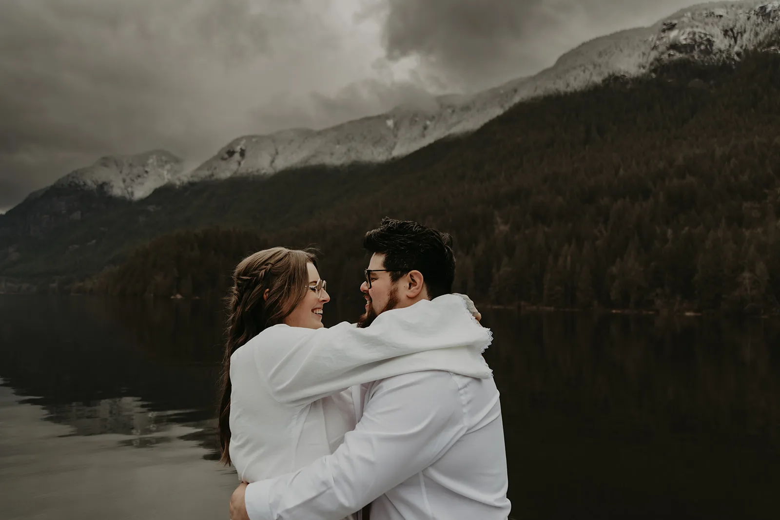 Newlywed couple embracing with mountains in the background behind them