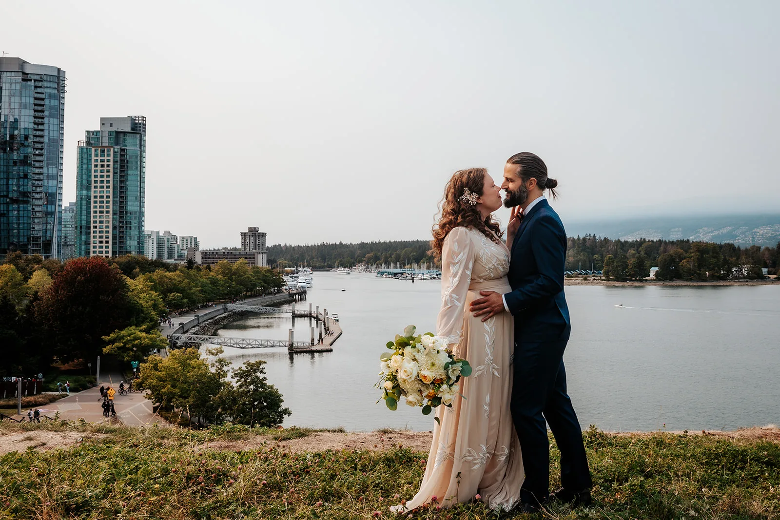 Newlywed couple posing along the Vancouver skyline