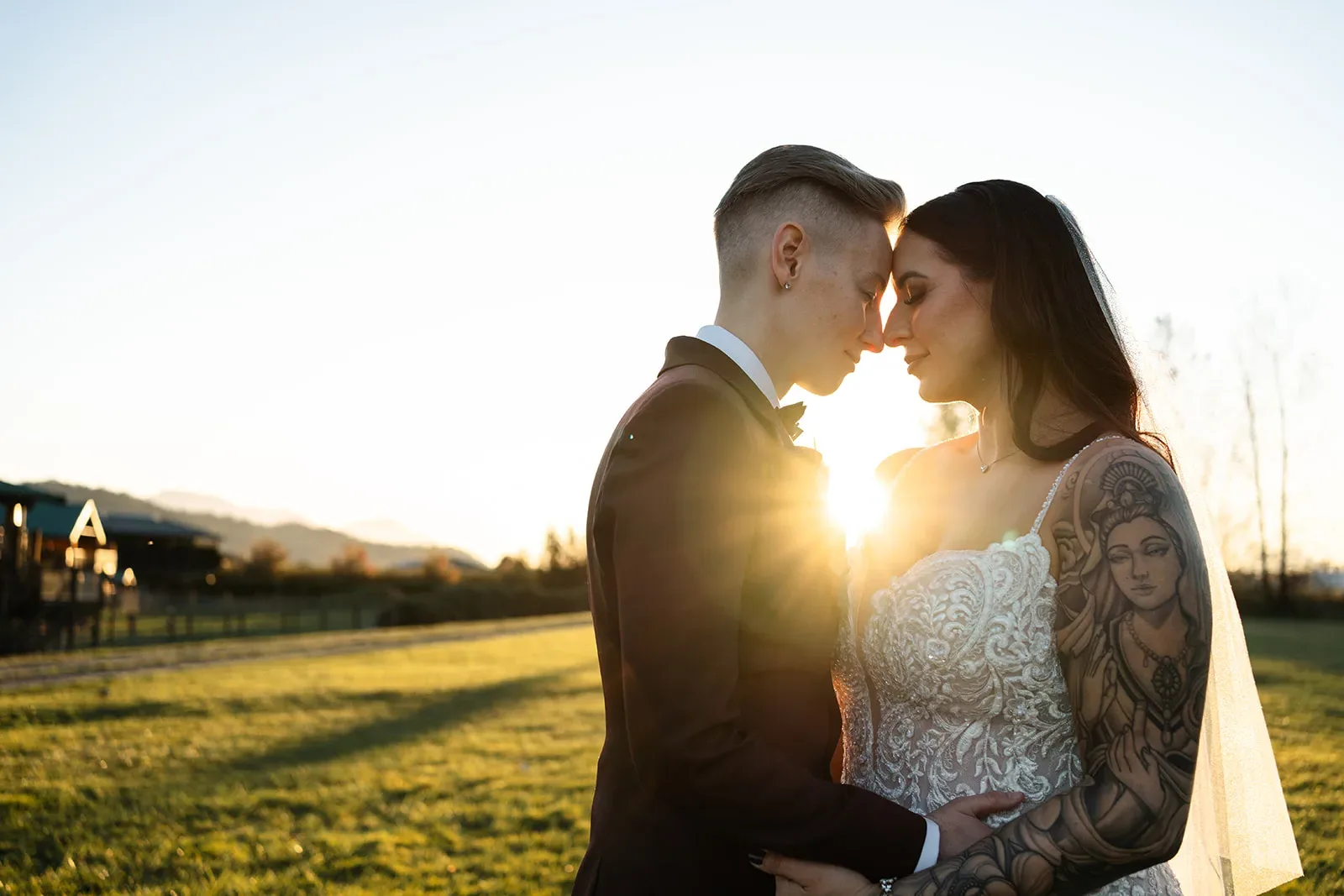 Newlyweds embracing with the sunset shining between them