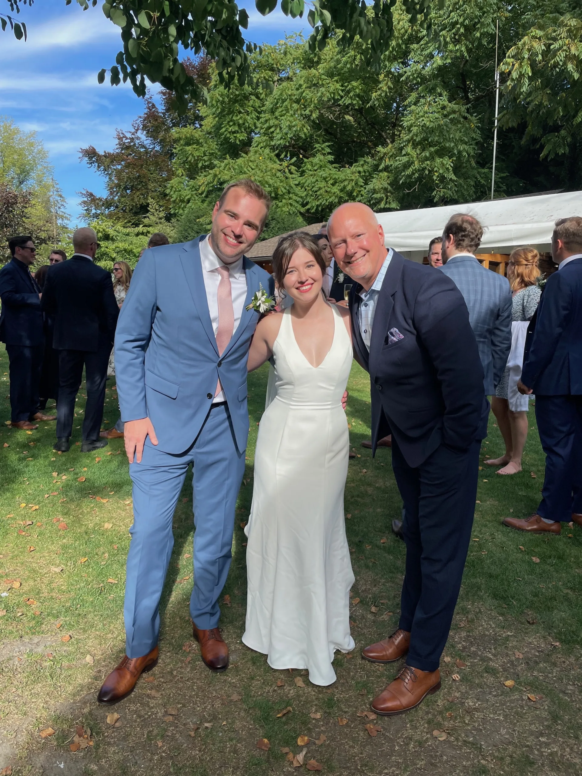 Newlyweds Sadie and Ross posing for a photo with Officiant Lonnie