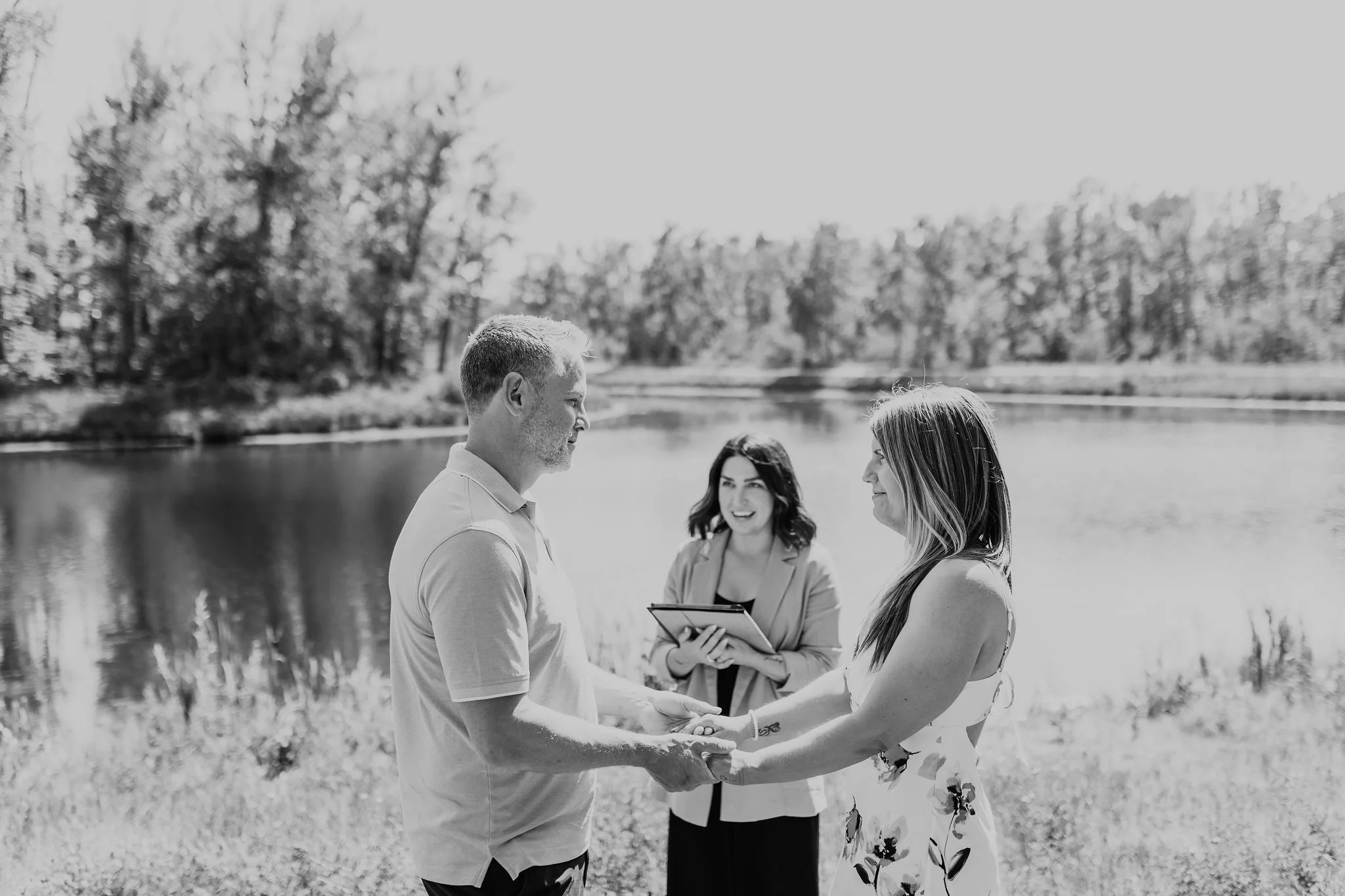 Black and white photo of Officiant Andria leading an elopement ceremony for a couple in Calgary