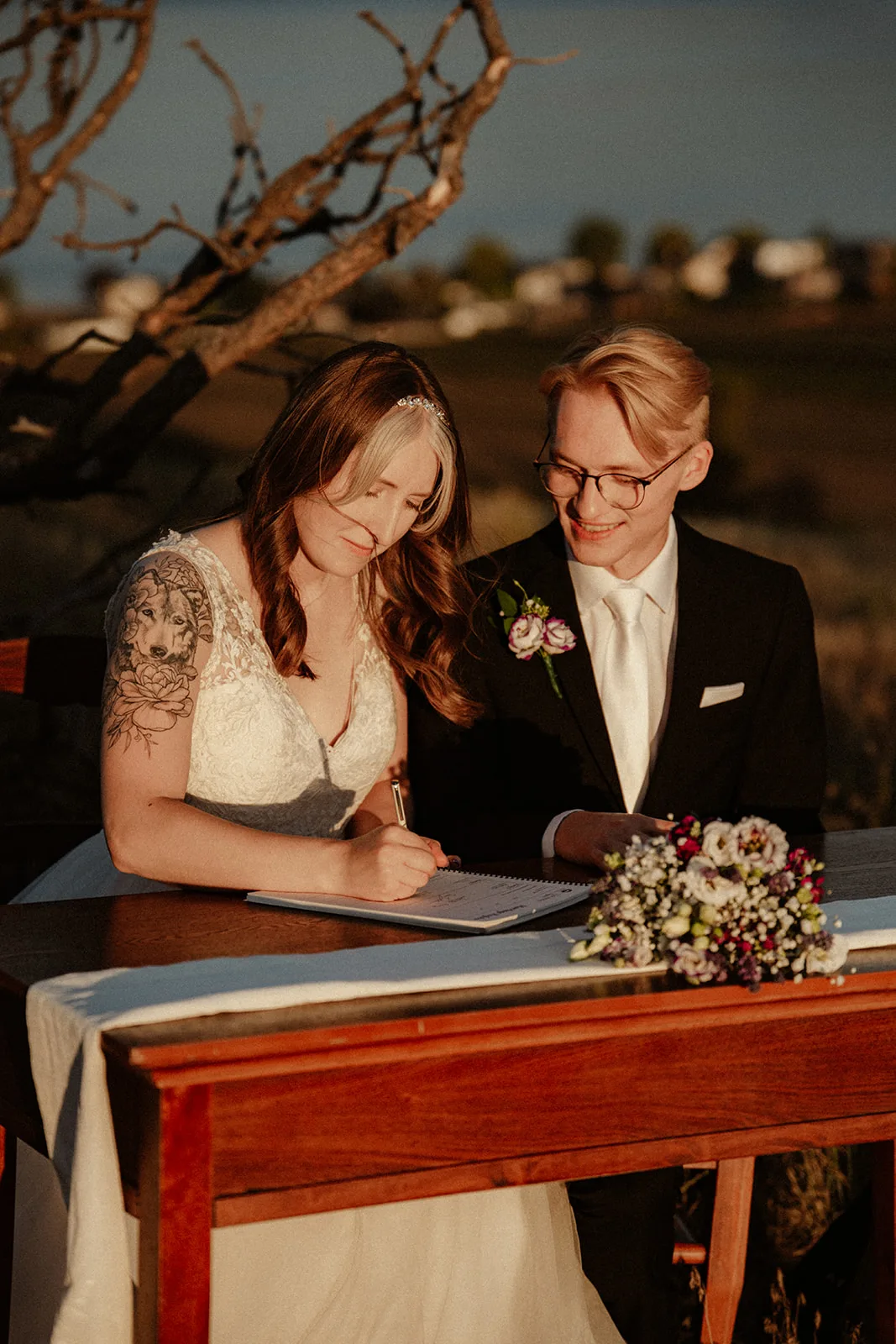 Rachel and Daniel signing their marriage licence at a signing table, Kayla Bowie Creative