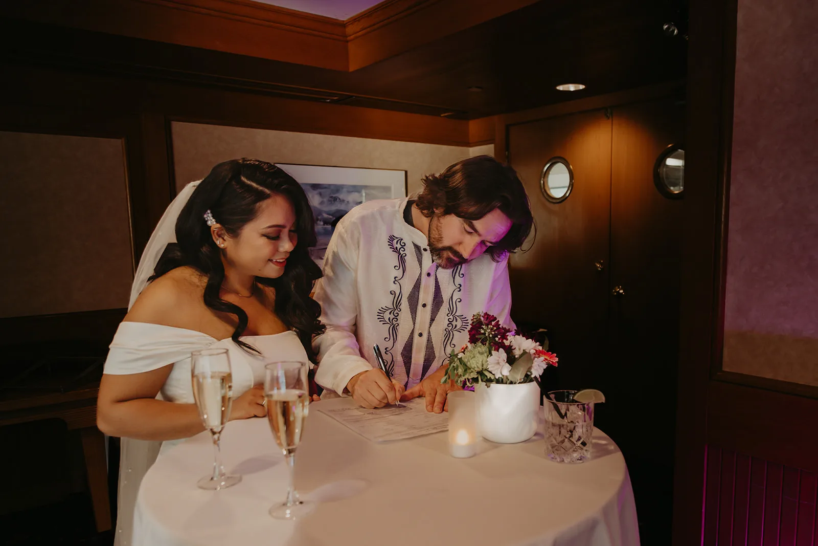 Ross and Kyra at their wedding ceremony signing table signing their marriage licence, by Erica Miller Photography