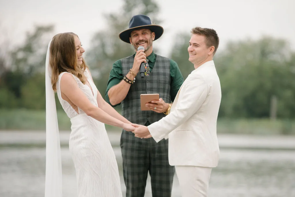 Devan and Jack laughing during their ceremony with Officiant Shawn at UBC Boathouse, Note Photography