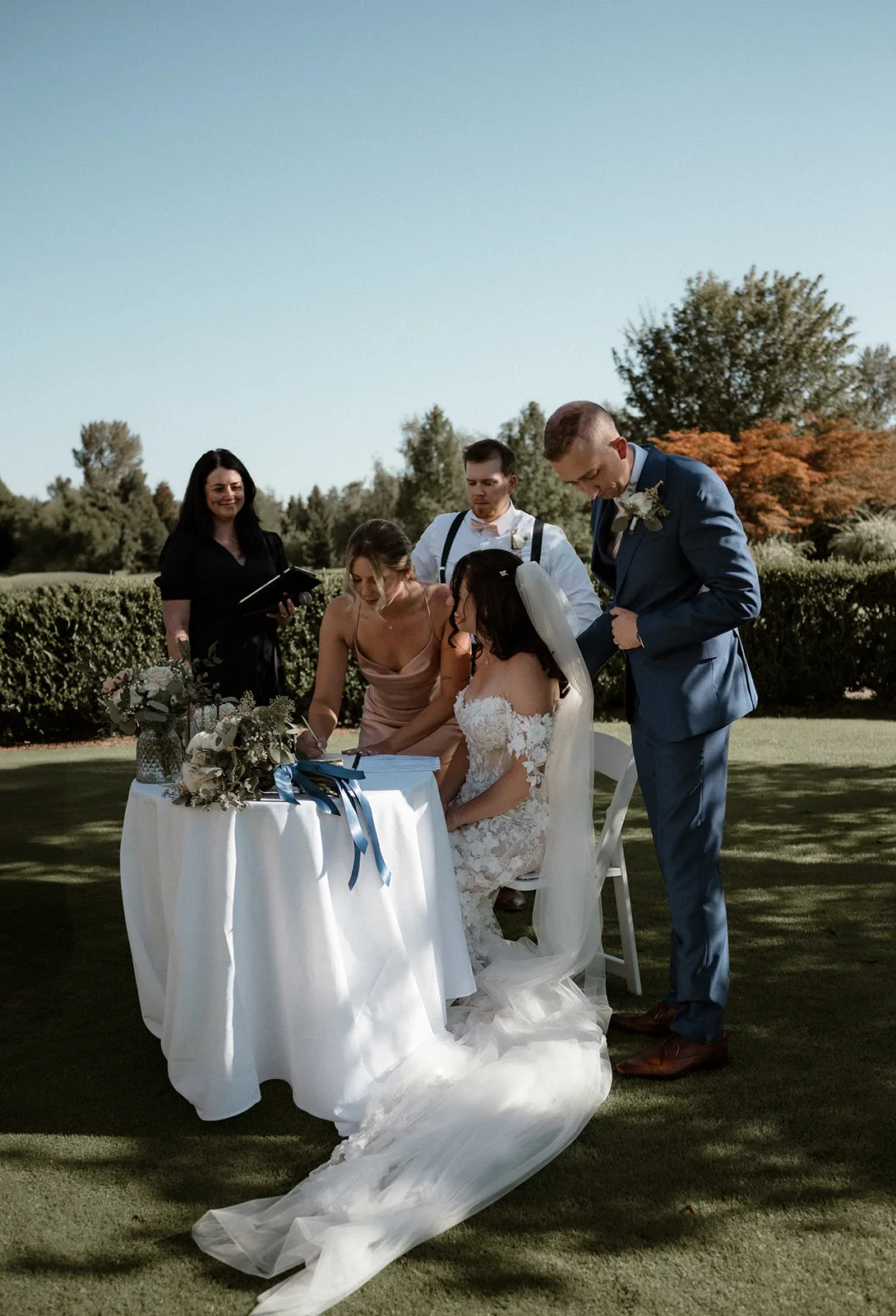 Brianna, Alex, Officiant Erika and their witnesses sit at the signing table to sign the marriage licence, Capri Kimberly Photo