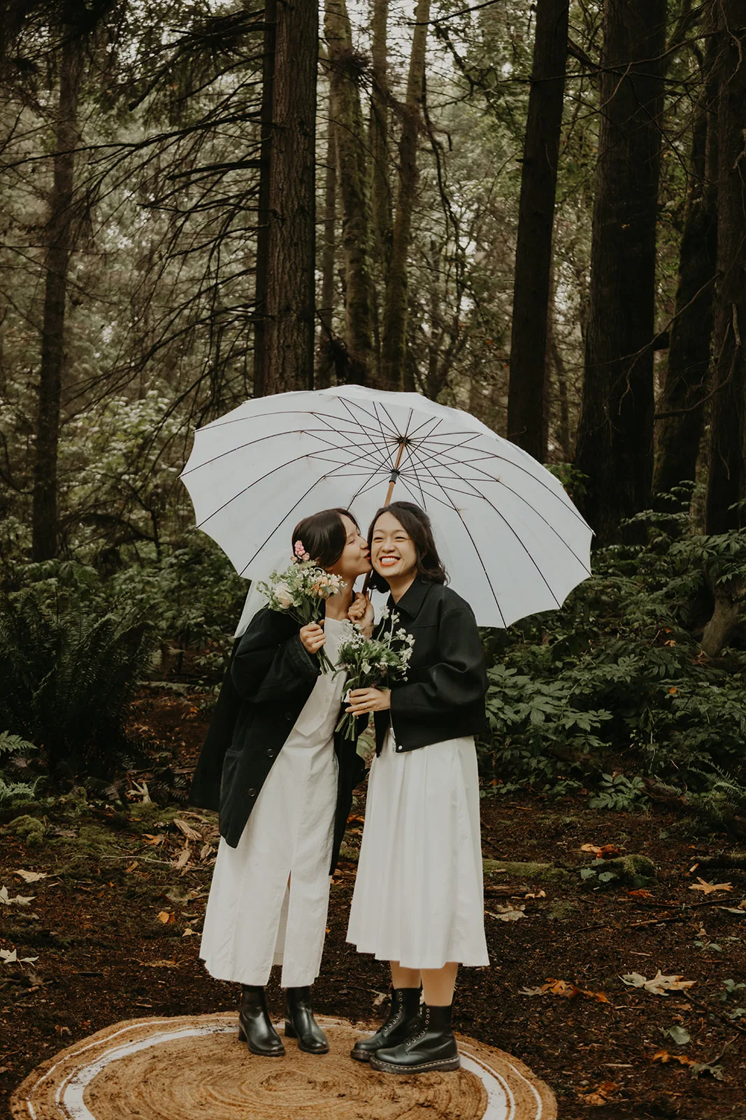 Jane and Sophia share a kiss on the cheek under an umbrella after their Young Hip & Married elopement, Erica Miller Photography