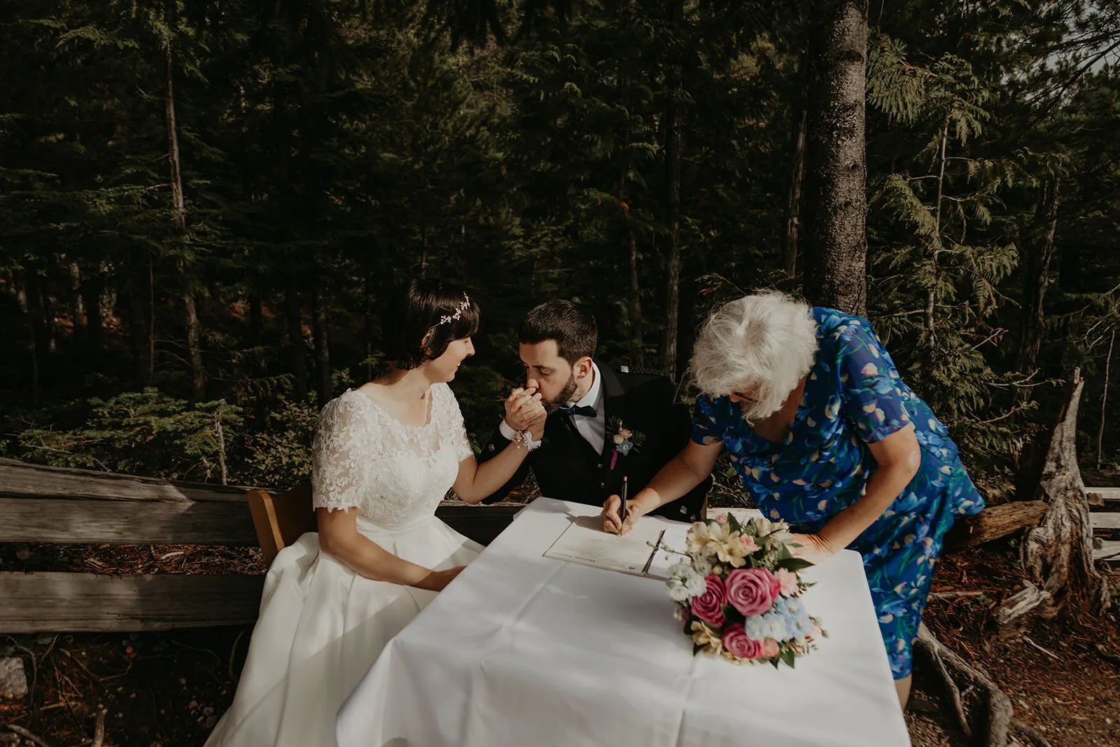 A witness signs the licence while John kisses Bride Jennifer's hand, Erica Miller Photography